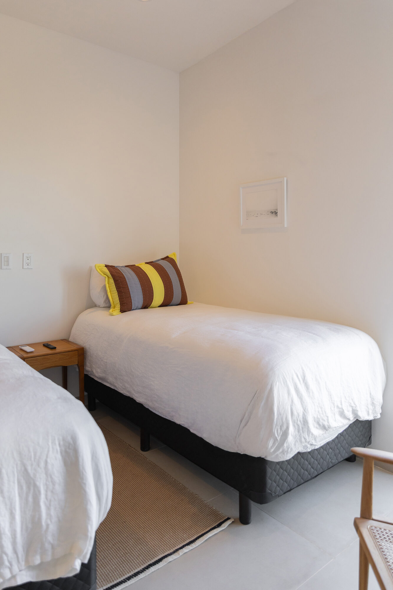 A bed in the second bedroom seen from the doorway, light from the window beside it