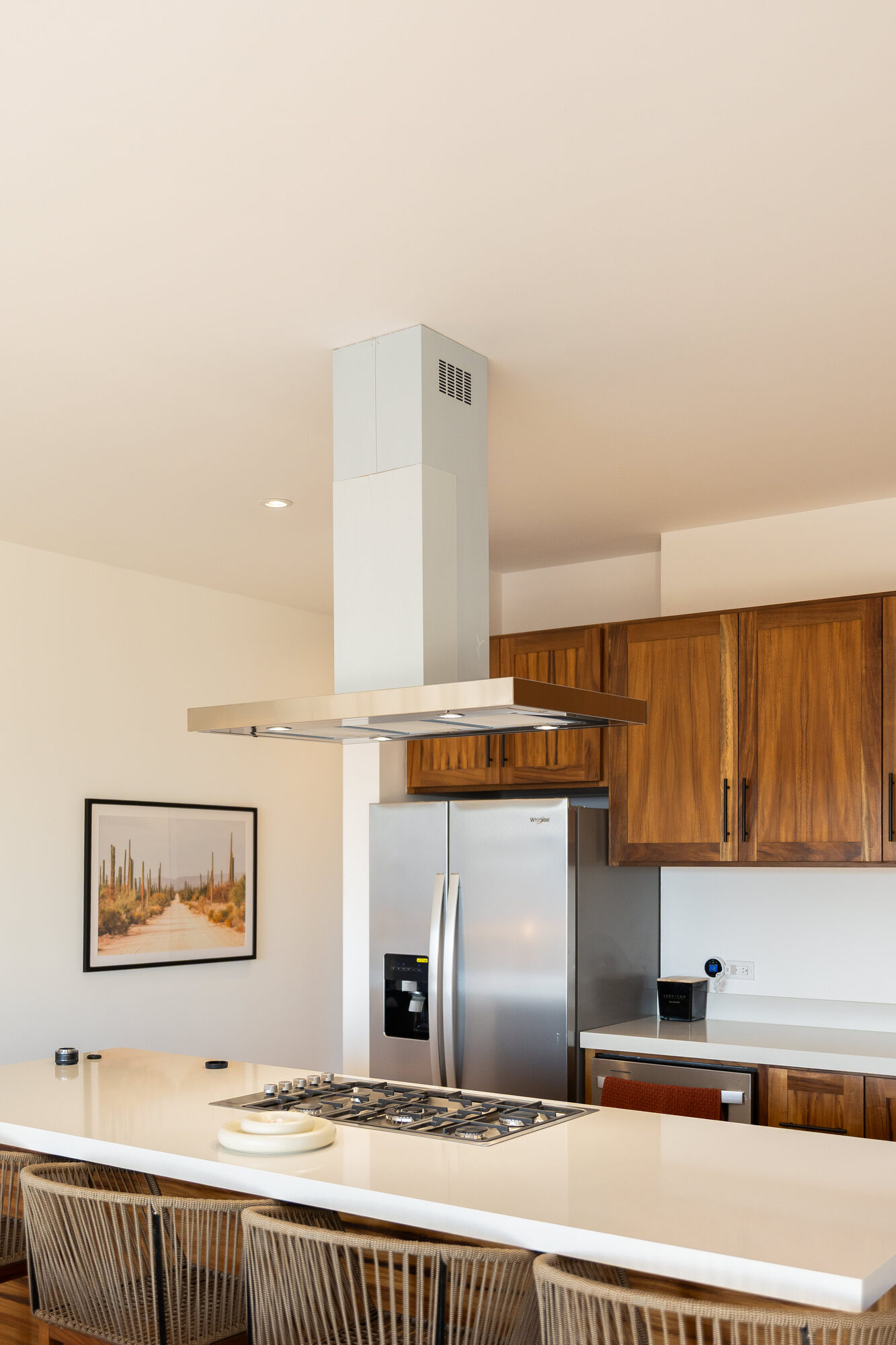 The kitchen range and hood set into pale cabinetry